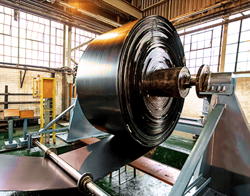 Equipamento industrial com componentes rotativos durante processo de fabrico. A imagem representa óleos de processamento, operações industriais e proteção de maquinaria.