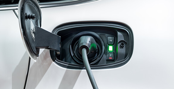 Primer plano del puerto del cargador del automóvil, con un cargador insertado.