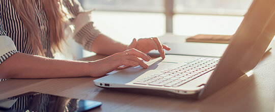 Fotografía de primer plano de manos escribiendo en una computadora portátil.