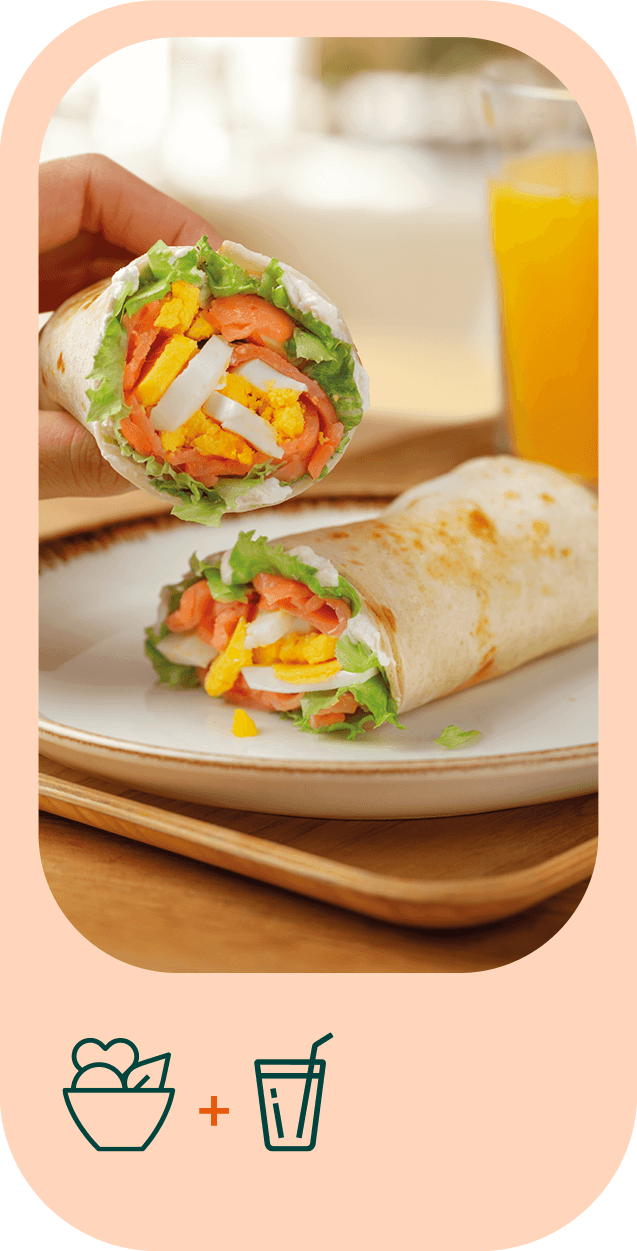 Fotografia em grande plano de um wrap cortado a meio. No seu interior é visível alface, ovo cozido e salmão. 